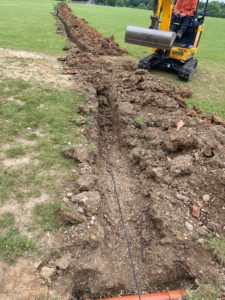 Image of a trench being dug for trench for access control system and gate automation