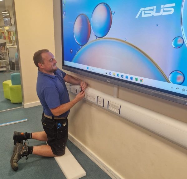 Image of an engineer installing classroom screens